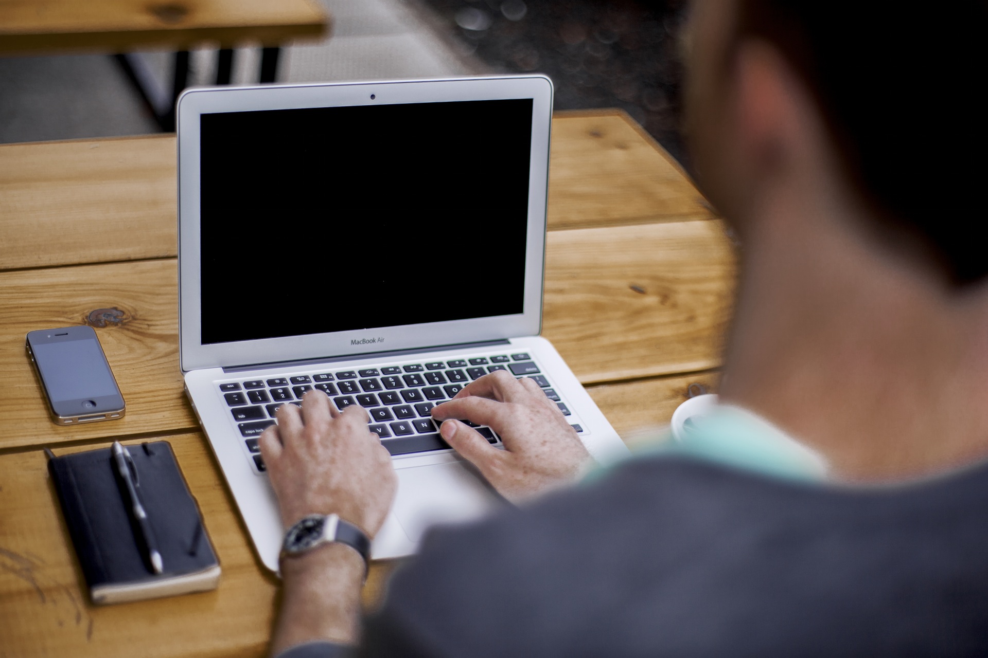 应用ing to OU MPGE from laptop. Person-typing-on-a-laptop-with-phone-and-notebook-next-to-them