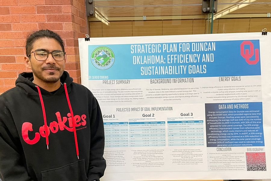 SES student standing next to his poster.