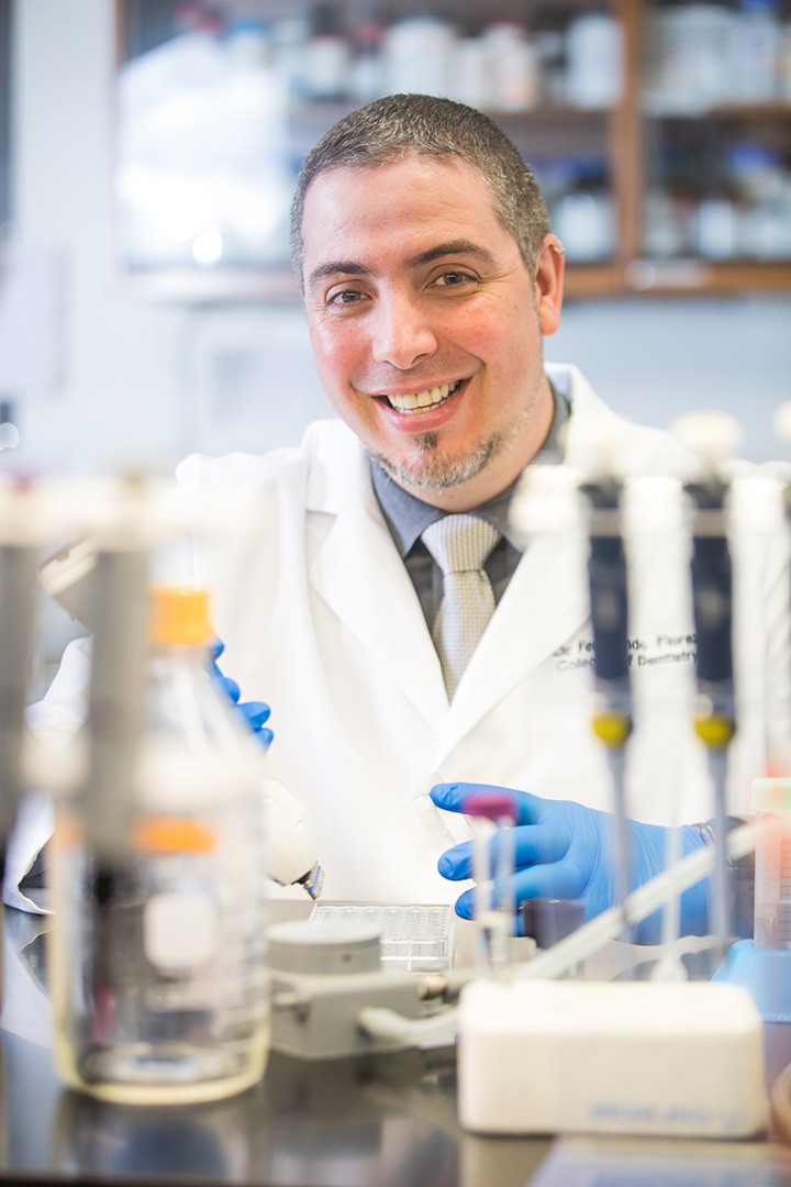 Doctor smiling in lab amongst lab equipment