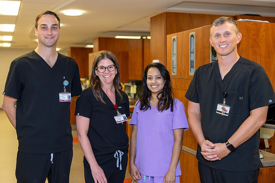 Four College of Dentistry faculty members stand in a row.