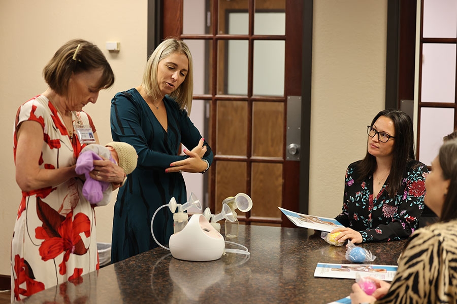 Two people demonstrate some of the training aids they use to help new mothers breastfeed.
