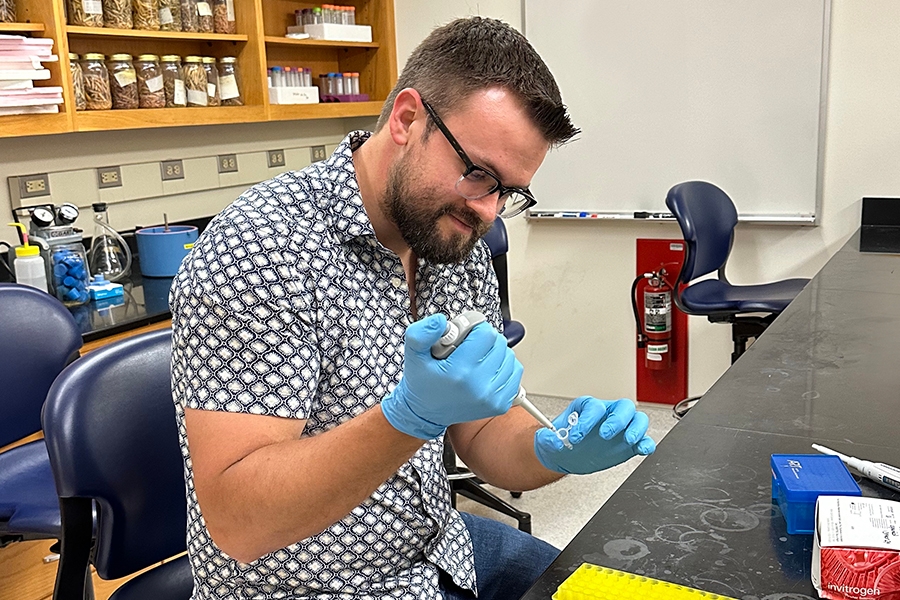 Chris McLimans uses a pipette in Dr. Hambright's lab.