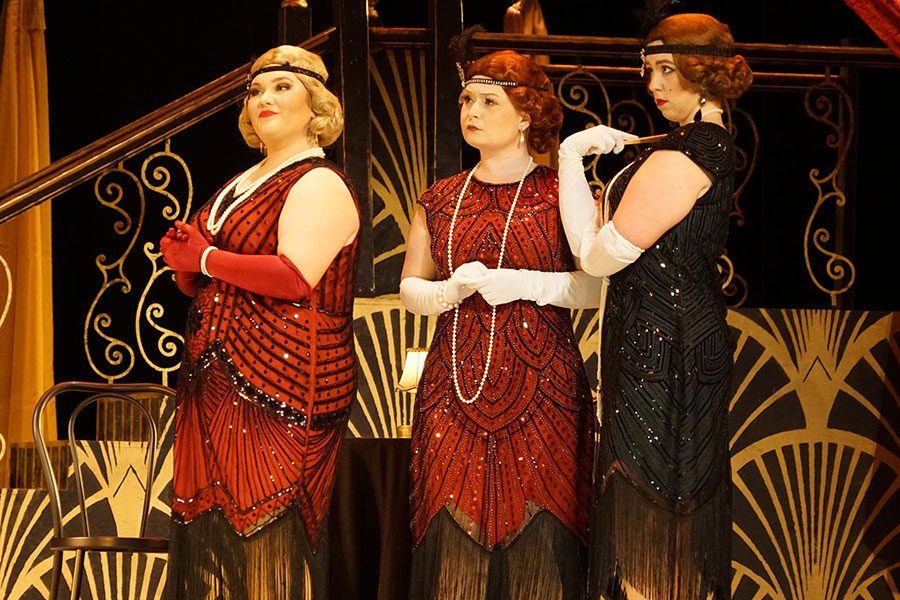 Three students in 20s flapper apparel on stage.