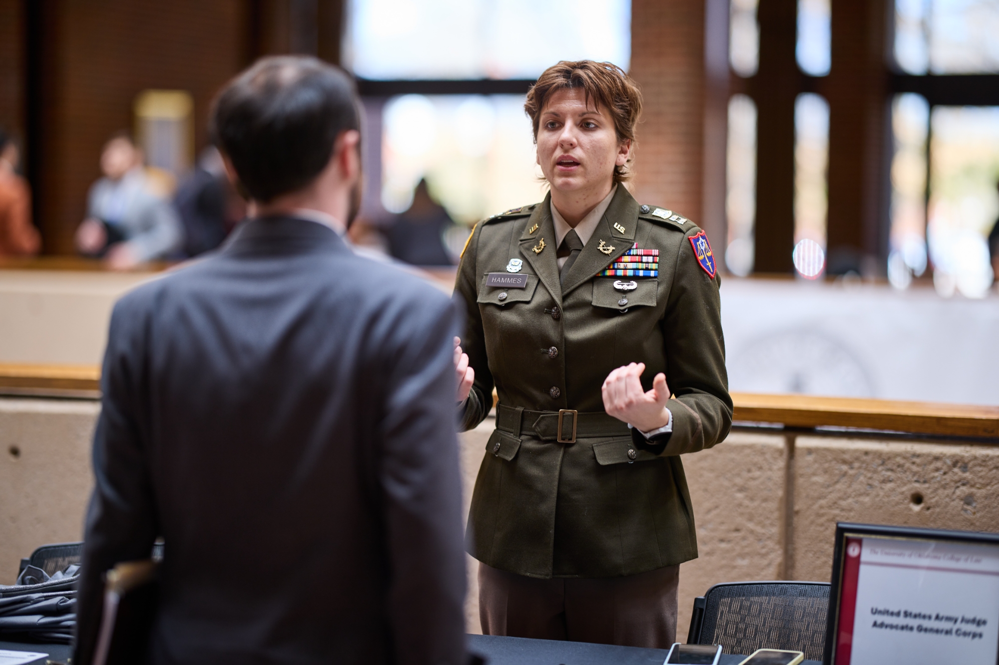 An individual in military uniform speaks with a career fair attendee.