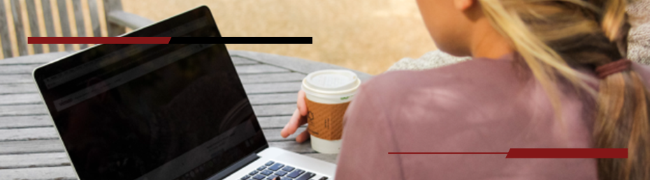 Female student working on a laptop outside.