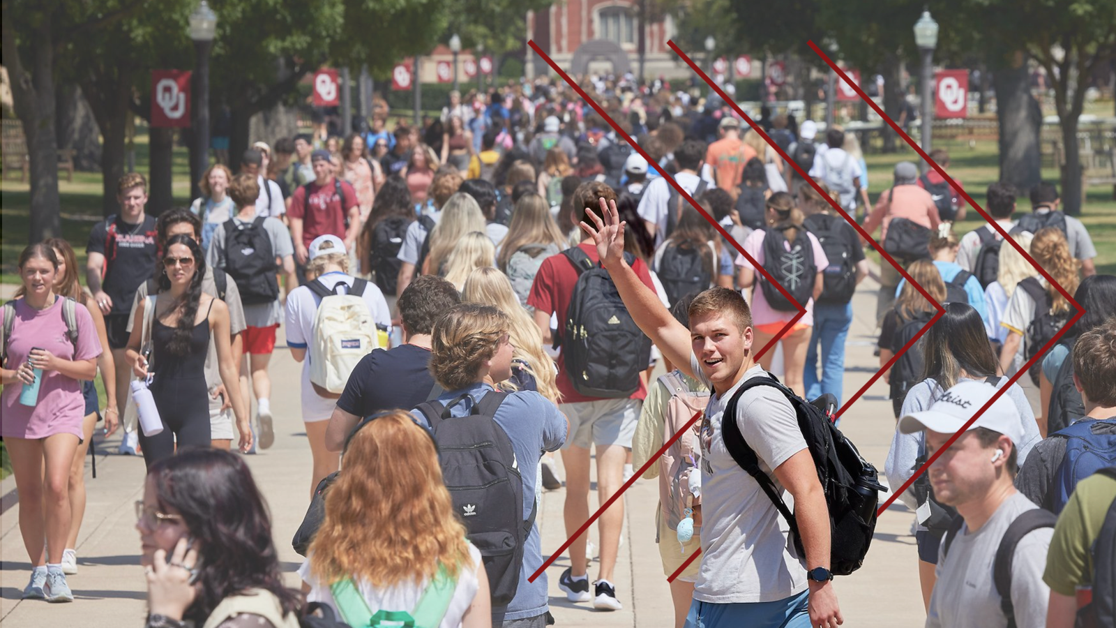 Large crowd of students with one student turned around waving.