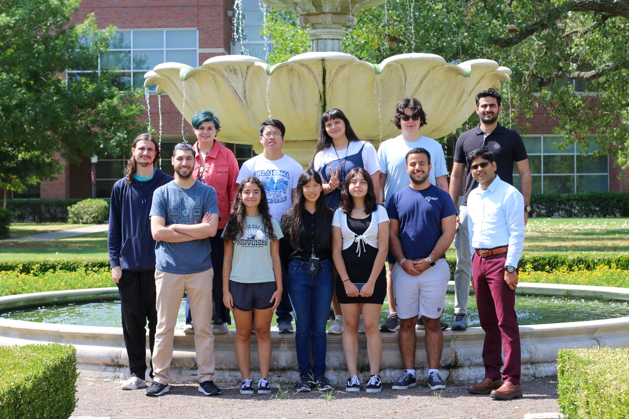 Students posing for a photo in front of a fountain. 