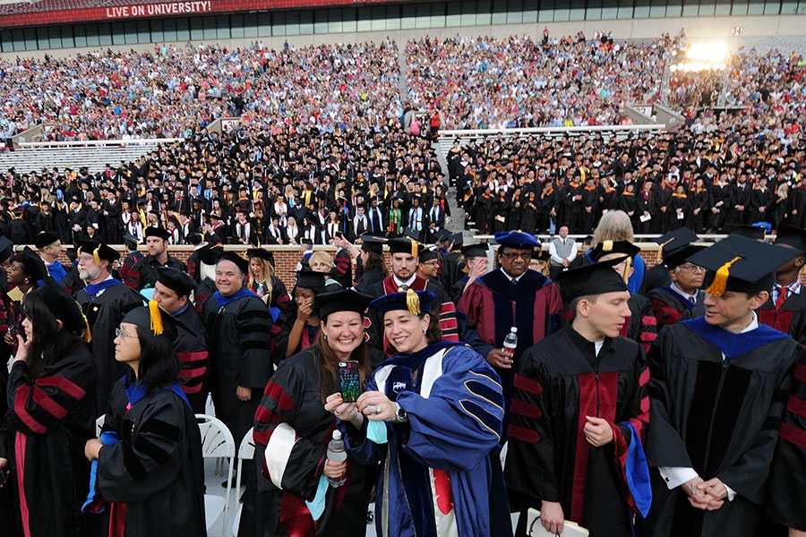 Students and faculty in regalia attend a commencement ceremony.