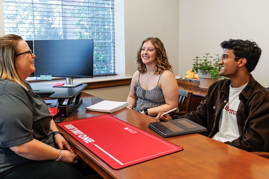 Two students meeting with a staff member in the Center for Student Success.