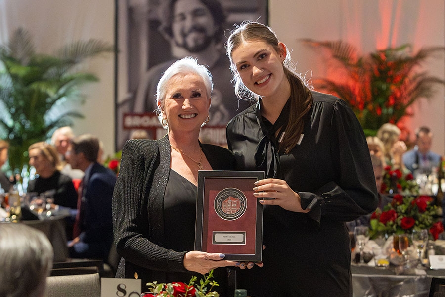 Alumnae Mary Durie, accepting a recognition plaque from the Adams Society.