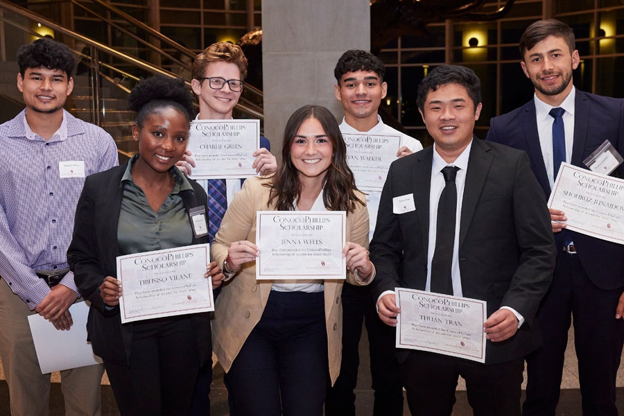 A group of seven proud MIS students displaying their scholarship certificates.