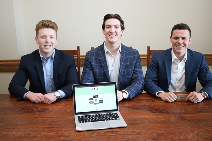 Entrepreneurship students sit at table with laptop