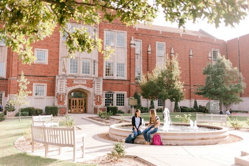 Students sit outside of Price Hall