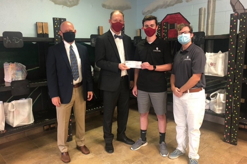 Jeffrey Schmidt (far left) and members of the OU Federal Credit Union Financial Literacy Club present a check to the OU Food Pantry