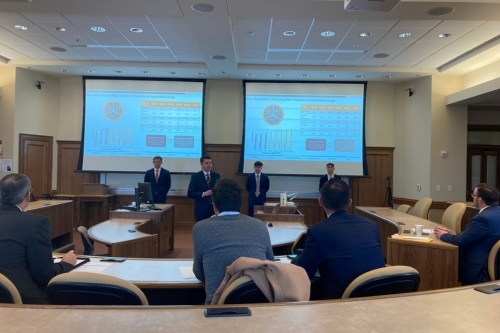 Students stand in the front of a classroom, giving their presentations for the CFA Challenge