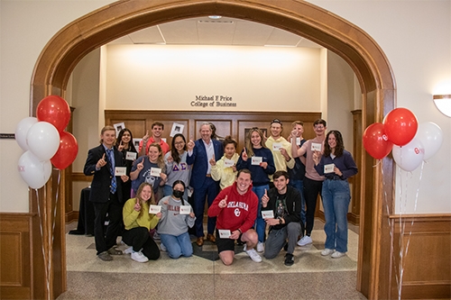 Dean Corey Phelps and a group of students pose for a group photo in Price Hall to celebrate the success of business week