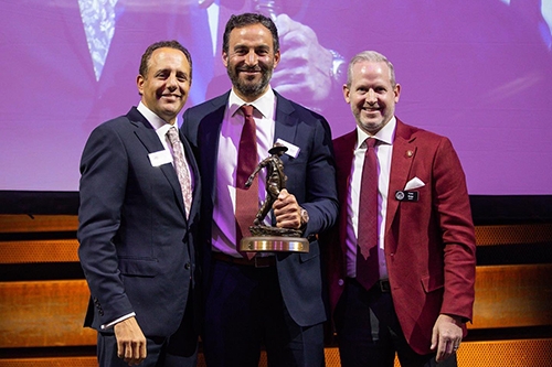 Michael Horton stands on stage with Price College dean, Corey Phelps and OU President, Joe Harroz, Jr., during his gift recognition