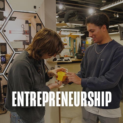 Two students work together on a 3D printed porotype in the fabrication lab.