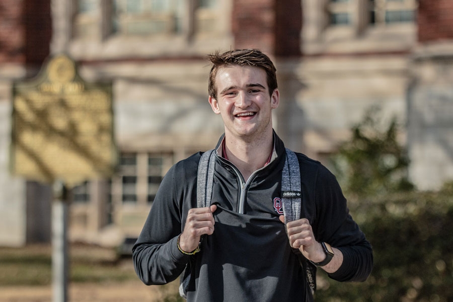 Christopher Firch standing outside of Adams Hall. 