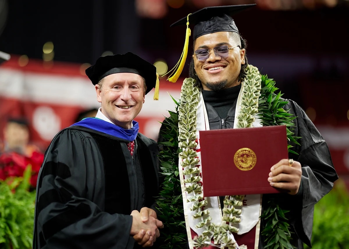 OU faculty member shaking OU graduates hand