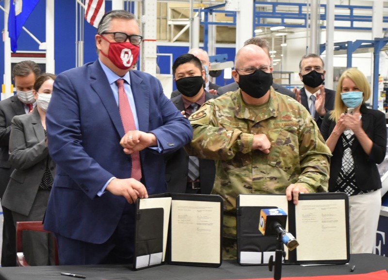 Dr. Tomás Díaz de la Rubia, University of Oklahoma vice president for Research and Partnerships, left, and Brig. Gen. Jeffrey R. King, Oklahoma City Air Logistics Complex commander, seal the signing of an Educational Partnership Agreement with an elbow bump July 14, 2020. The agreement will help both institutions cultivate aerospace technology development and will improve and enhance education in science, technology, engineering, and mathematics at the university. (Air Force photo by April McDonald)