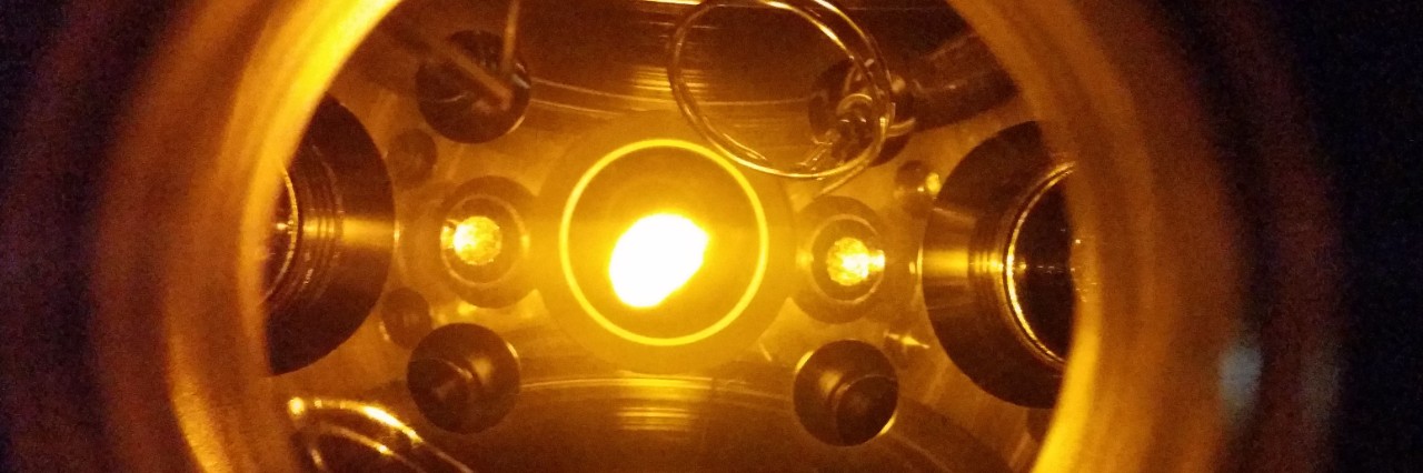 An ultracold cloud of sodium atoms in the center of the vacuum chamber is suspended by laser beams and magnetic fields. The size of the cloud is about 1 cm. Microwave and radiofrequency antennas, visible on the top left and top right, are then used to control spin-changing collisions and investigate the generation of entanglement.