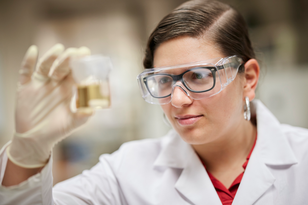 Graduate student Ana Carolina Jerdy holding beaker of catalyst solution.