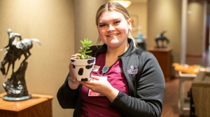 Student showing off their pot and plant.