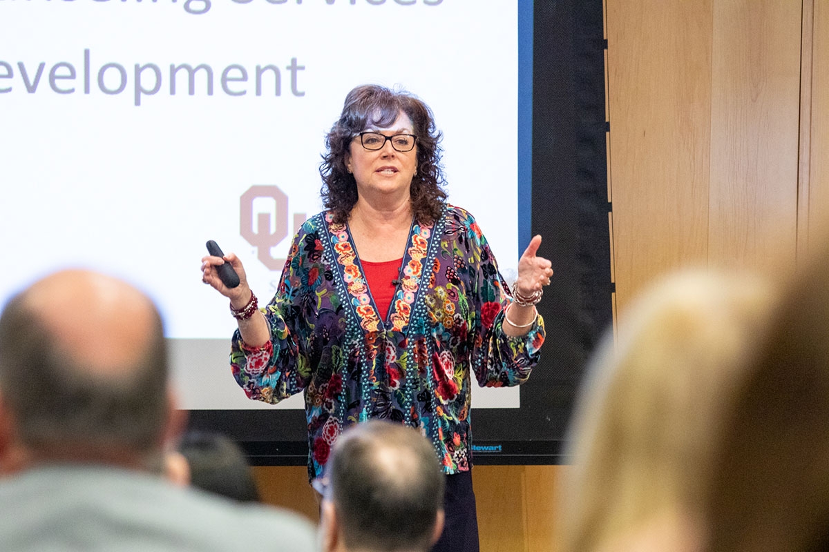 Dr. Teri Reed speaking to a group of people at a meeting.