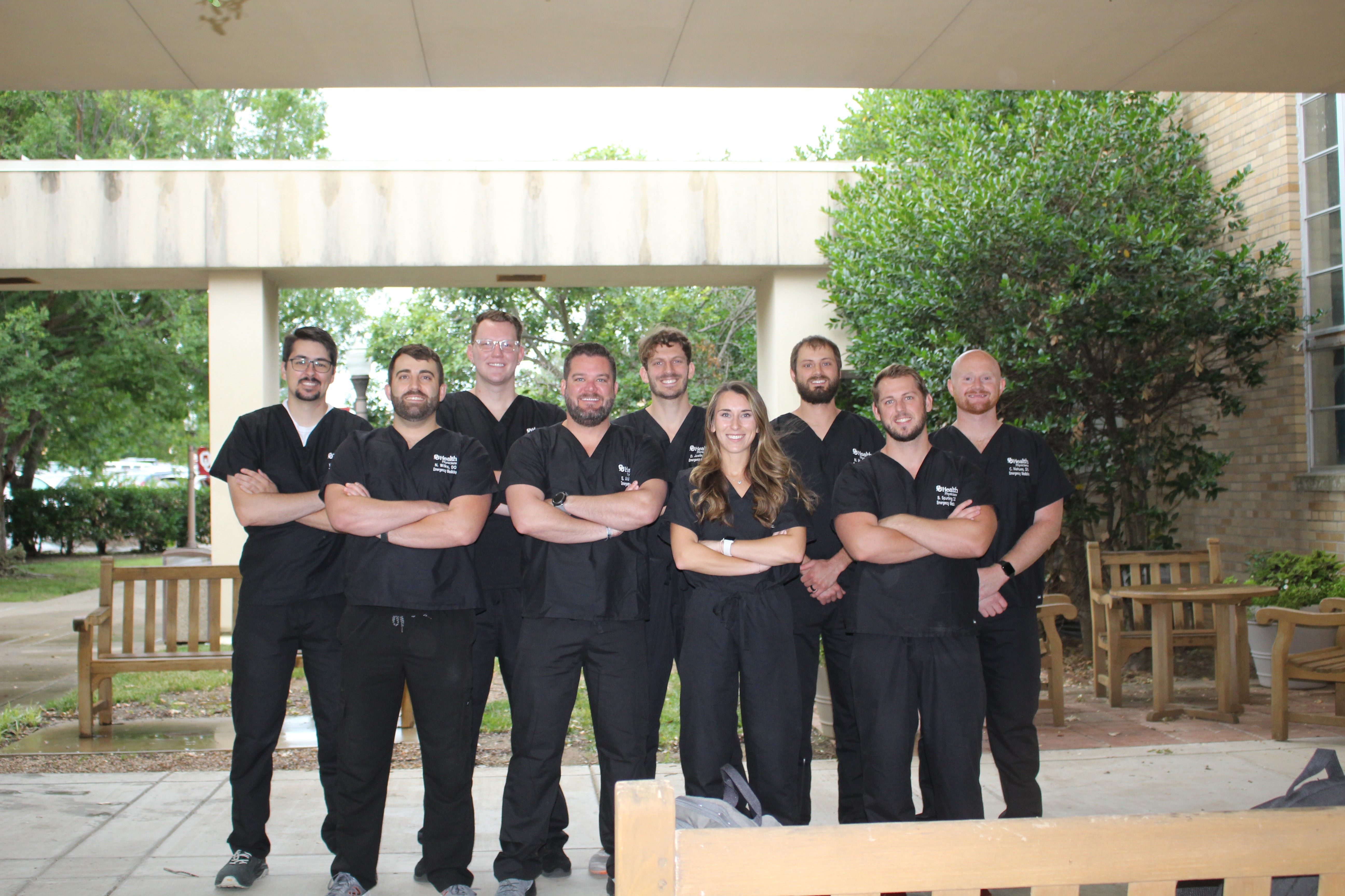 A group of students in black scrubs, posing for a group photo.