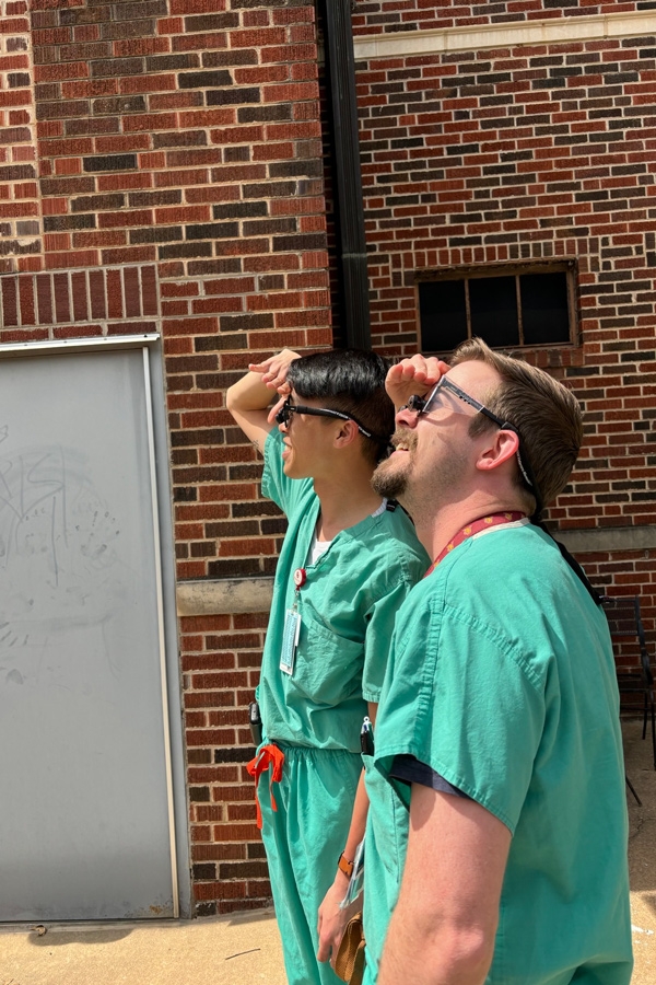 健康 residents in scrubs looking at the sky outside.