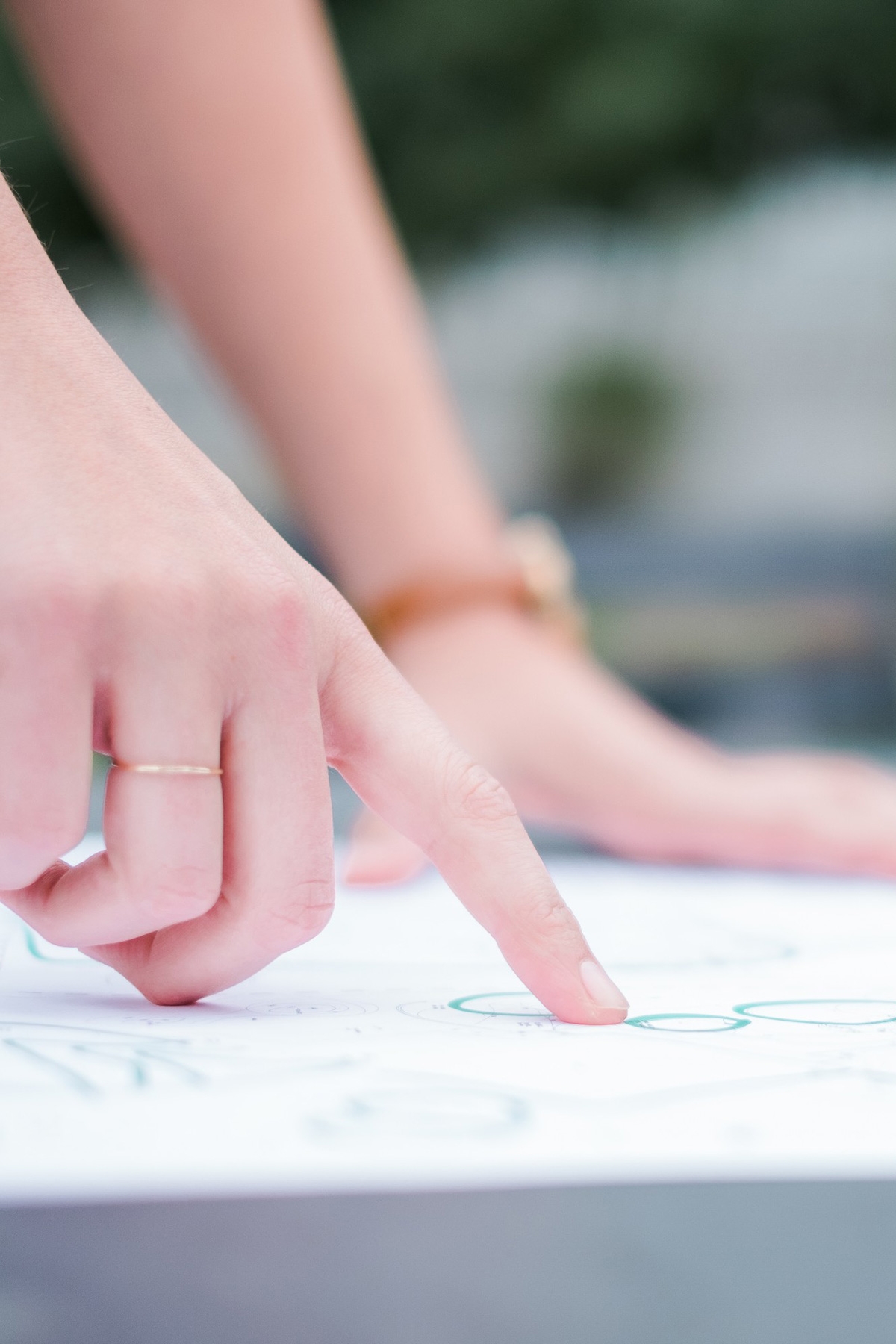 A student places a finger on a piece of data printed on an urban design plan