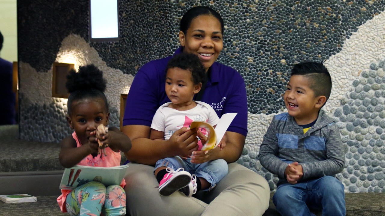 A woman sits with three children. A woman sits with three children.